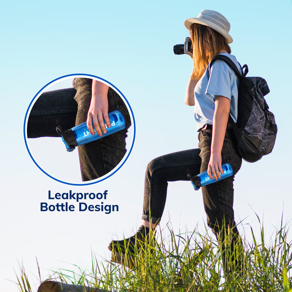 Woman hiking holding the Prep-Right Survival Water Filter Bottle upside down showing it has a leakproof bottle design